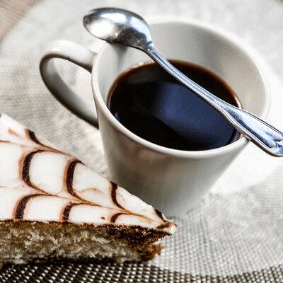 Ein Stck Kuchen und eine Tasse Kaffee mit Kaffeelffel.